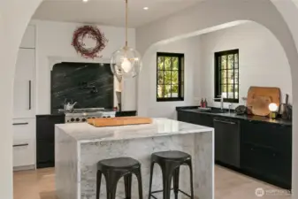 Premium details include a Bluestar gas range with Waterworks pot filler and Sub-Zero refrigeration (2), all illuminated by an authentic Lindsey Adelman terrarium pendant.