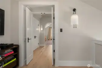 From the second-floor landing, double french doors and a graceful archway lead to the serene primary bedroom.