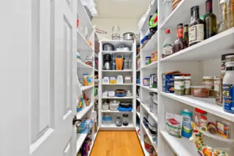 This walk-in pantry is a convenient storage space. Wall to wall shelving provides ample space for home and kitchen storage.