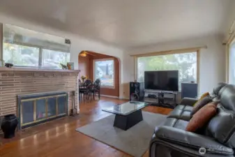 The spacious living room with its wood burning fireplace and original hardware floors are the great foundation showing the potential of this home.