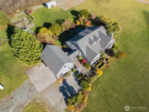 Hops trellises and two young apple trees sit adjacent to the container, adding beauty and future fruit production.