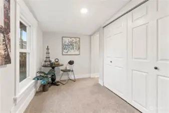 View of the Den with stairs leading to 3rd Bedroom and Basement. Closet Doors hide the laundry room.