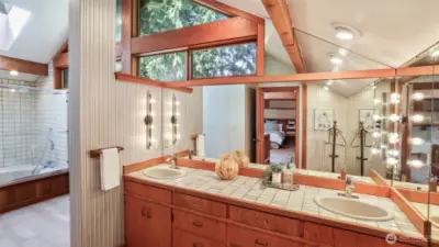 Not your standard bathroom. A soaking tub, dual vanities, vaulted ceiling, and wood framed windows extend the refined charm found throughout the home.