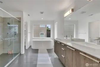 A glorious 5-piece bath with full height tile surround, double vanity, soaking tub, and toilet room.