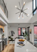 The kitchen boasts impressive double-height ceilings and features a generous island, creating a stunning focal point and providing ample space for culinary activities.