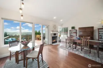 The area adjacent to the kitchen provides versatile dining possibilities, with the far left space adaptable for various uses, such as a generous sitting area to relax by the wood-burning fireplace.