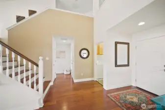 Step back inside to discover the other wing of the main level, where convenient laundry and two-car garage access lie to the right, and the luxurious primary bedroom awaits to the left.