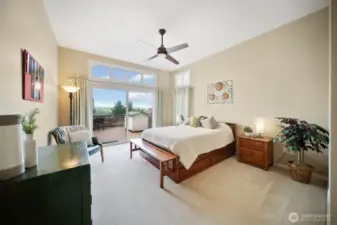 The spacious main floor primary suite provides direct access to the expansive back deck with stunning views and features lofty cathedral ceilings.