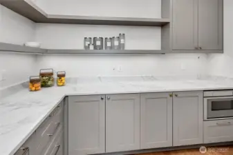 A dream pantry with refrigerator drawers, plenty of prep space, storage galore and microwave drawer.