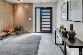 Wood paneled entry with designer lighting, paneled walls and custom flooring.