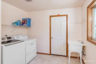 The Laundry room has A Utility Sink, Private Toilet Room and Access to the 3 car garage with Shop Area