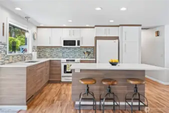 Modern chef’s kitchen with oversized quartz island, bar seating, pendant lighting, and custom cabinetry—blending functionality with style in every detail.