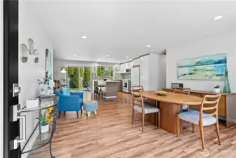 Welcoming entry leads into a bright, spacious great room with open sightlines to the modern kitchen, cozy living room, and inviting dining area with patio access.