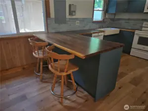 This large beautiful wood countertop serves as both great kitchen counter space as well as a convenient extra dining spot.