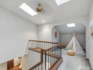 Sun-drenched upstairs loft with skylights, arched nook, and endless possibilities — home office, reading retreat, or creative studio