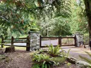 Entry gate.  Photo shows the road and fencing that follows the West property line.