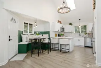 Dining rm, breakfast bar & kitchen. Skylight, white cabinets, high ceilings, lots of light.