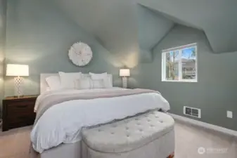 Spacious primary bedroom with vaulted ceilings.