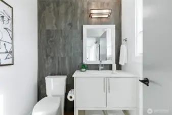 Powder room for guests with impeccable modern design and tile wrapped wall