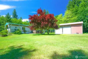 Home and detached garage overlooking the Little Quilcene River. Two-one acre parcels with potential for second home.