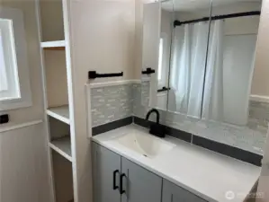 Bathroom with tile backsplash and linen storage area.