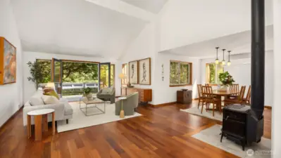 The living room exudes warmth and character with rich teak floors that glow in natural light. Whether you're curled up by the fireplace or entertaining guests, the space feels both elegant and welcoming.
