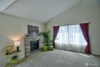 Vaulted ceilings, natural gas fireplace and grand picture window are features of the living room