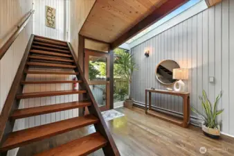Sunlit stairwell leads to the coastal-inspired primary bedroom. where sweeping ocean views and soft sea breezes await.