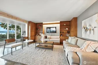 Expansive living room offering custom cabinetry, handcrafted shelving, and intimate built-in lovingly built over time by the home's original owners; perfect for displaying seaside treasures, curling up with a good book, or sharing sunset stories with loved ones."