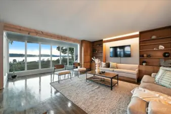Puget Sound views from this well-loved living room with expansive windows, rich hardwoods, and seamless indoor-outdoor flow.