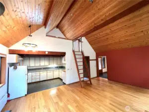 The dining area looking at the kitchen and loft space on the second floor.