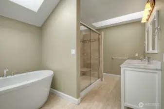 Primary bath with soaking tub, skylight, and double vanity