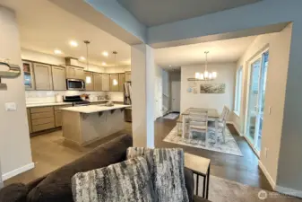 View from living room looking towards kitchen with eating bar and ample dining room.