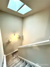 Stairway from upper level shows skylights.