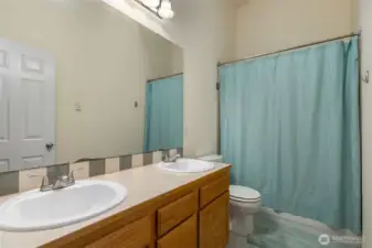 full bathroom on top level with vaulted ceilings and a skylight