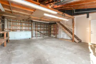 Shop in back with workbench, shelves, storage. Door to studio on the right.