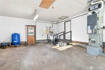 Garage attached to house with new well tank, on -demand hot water, new utility sink, natural gas furnace and workbench.