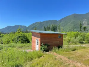 Cozy artist studio for temporary use on the second parcel. Both parcels have underground power and recently installed fiber optic cable soon to be hooked up. They each have their own well.  What a great way to start the dream.