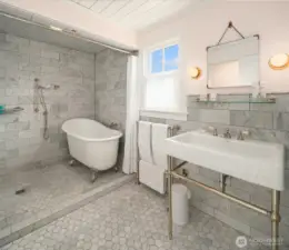Spa-like serenity—Carrera marble, a cast-iron soaking tub, and luxurious finishes throughout.