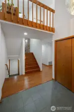 Open, multi-level entry showcasing warm hardwood floors, clean architectural lines, and a striking loft overlook. Light-filled space connects seamlessly to upper and lower levels, enhancing flow and functionality.