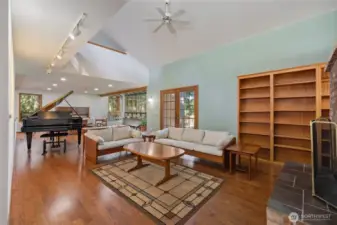 Open-concept living area with vaulted ceilings, rich hardwood floors, and abundant natural light creating a warm, inviting atmosphere.