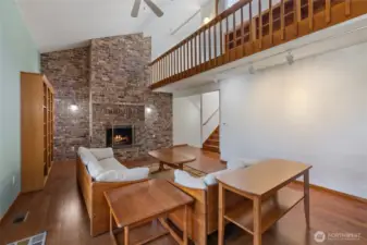 Spacious living room with loft overlook, showcasing clean lines, volume ceilings, and seamless flow to adjacent spaces.