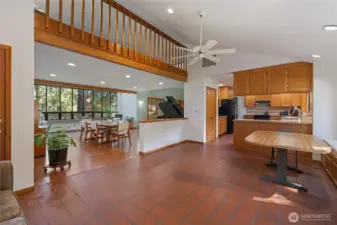 Expansive open-concept living and dining area with warm hardwood floors, soaring ceilings, and seamless flow to adjacent spaces—ideal for entertaining and everyday living.