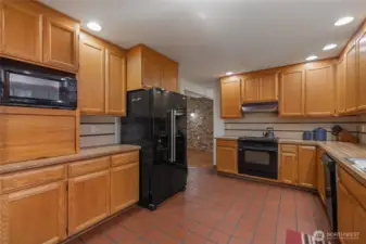 Spacious kitchen with abundant cabinetry, generous counter space, and a large window overlooking the natural surroundings.