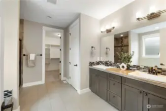 Primary suite bath with dual vanities soaking tub and large walk in closet