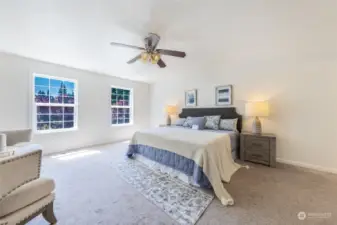Spacious primary bedroom on upper level with ceiling fan.