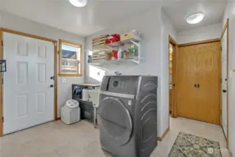 The utility room has soo much space, storage, shelving, utility sink and a door to the exterior!