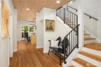 Solid wood floors are throughout the home graced by rich interior detail and many custom accents including metal rails and white washed wood paneled ceilings.