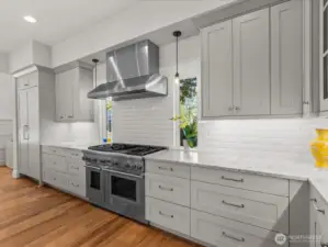 A built-in Thermador refrigerator, 6-burner gas stove, and commercial-grade hood blend seamlessly with sleek marble countertops and a custom tiled backsplash—creating a sophisticated culinary space that's as functional as it is beautiful.