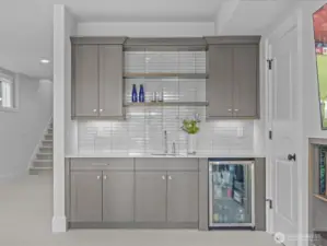 A sumptuous wet bar adds to the lower-level experience, complete with a Frigidaire beverage refrigerator—ideal for entertaining and effortless refreshment.